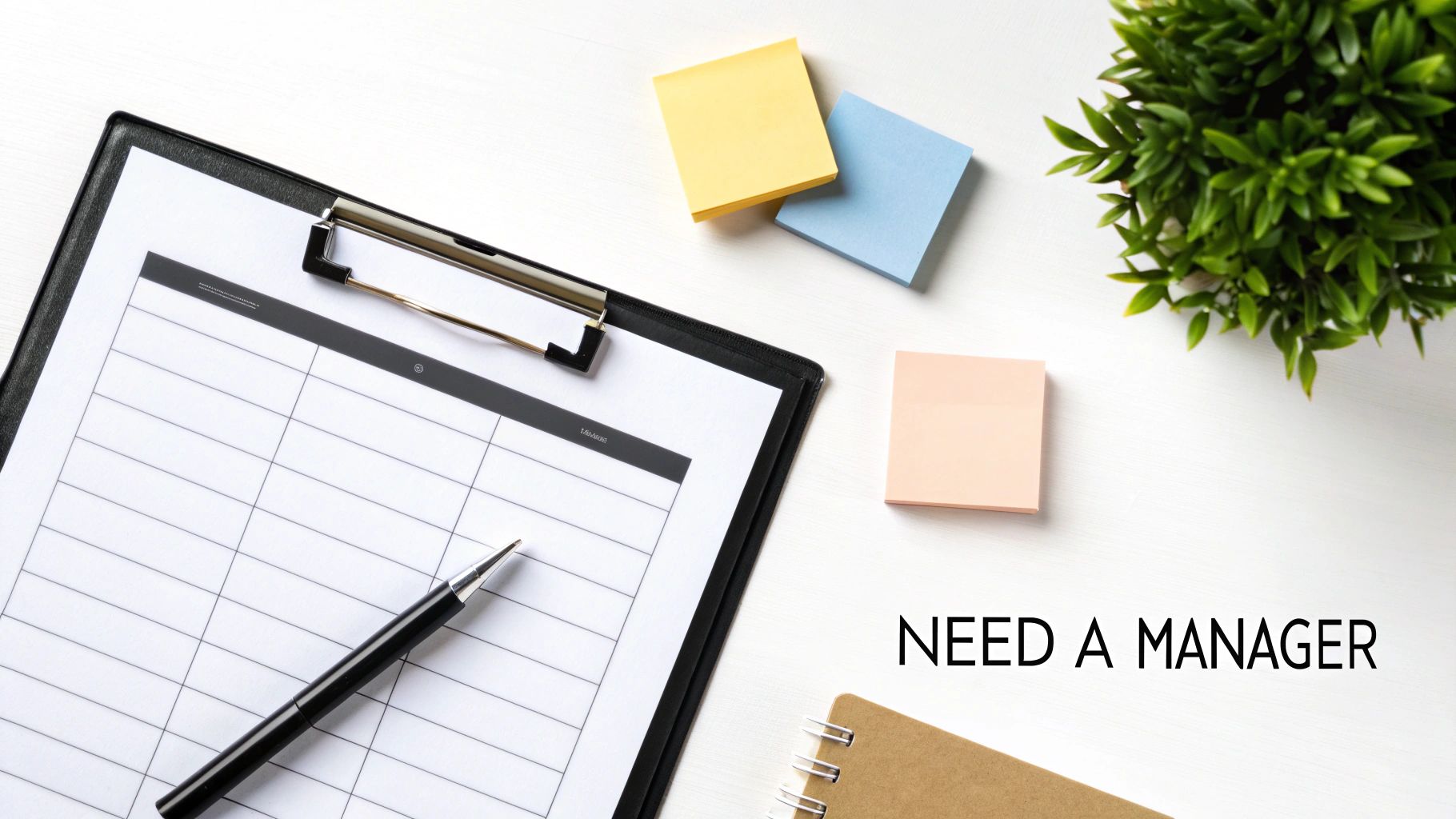 Flat lay of an organized white desk with a clipboard, pen, sticky notes, and text 'NEED A MANAGER'.