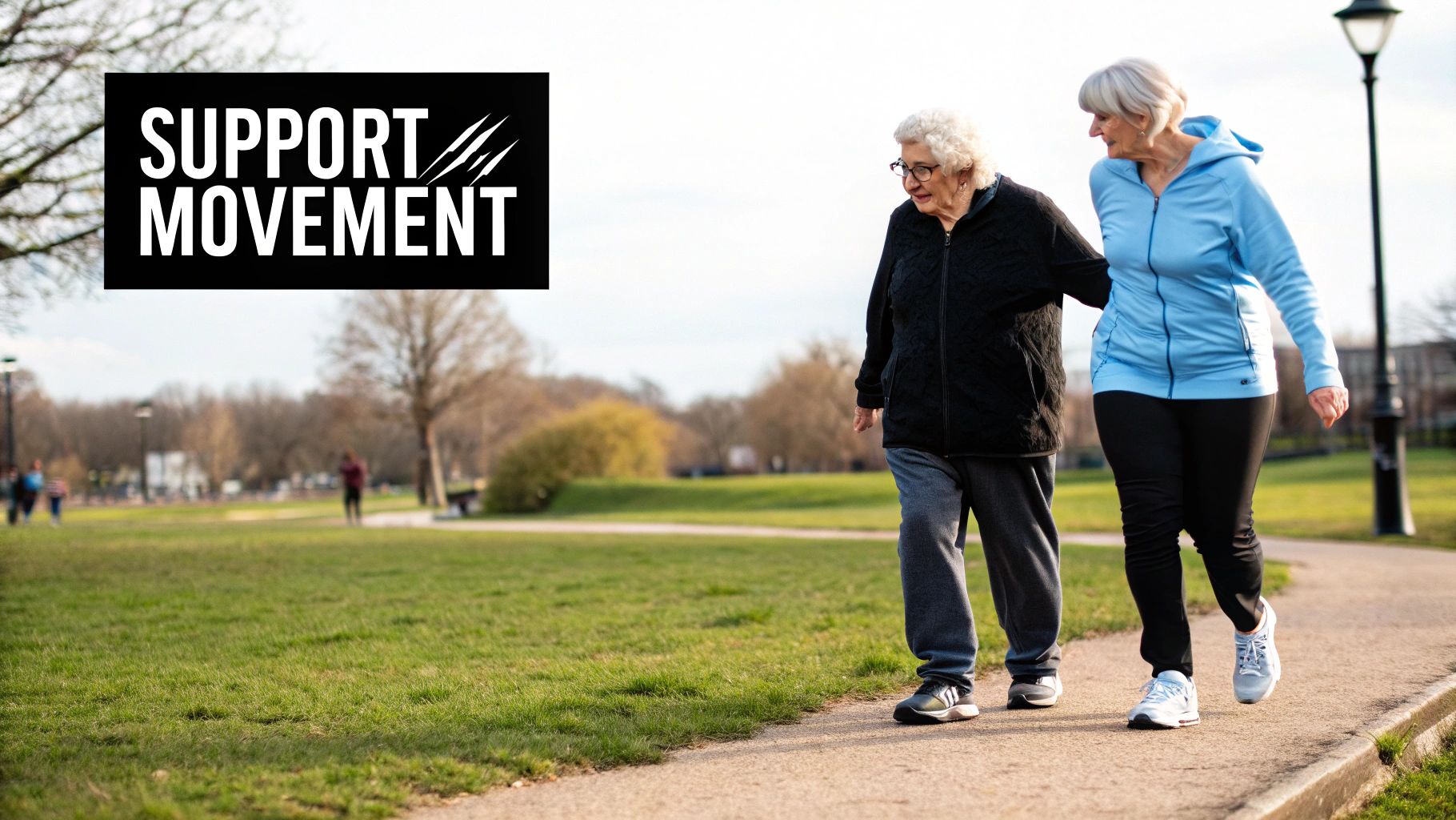 Two elderly women in sportswear walking together on a park path, one supporting the other.