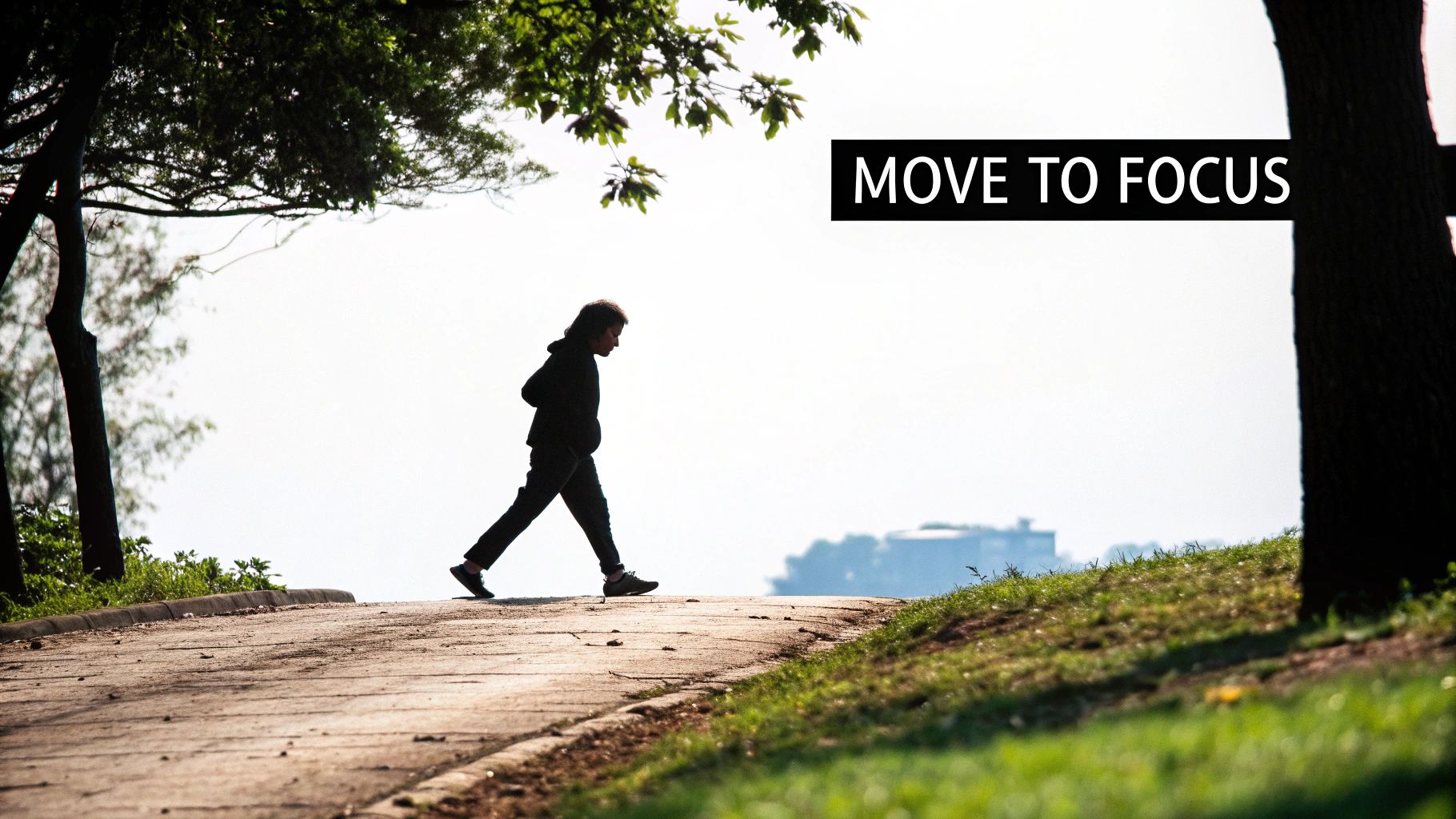 A silhouetted person walks on a park path with trees and grass, under a 'MOVE TO FOCUS' banner.