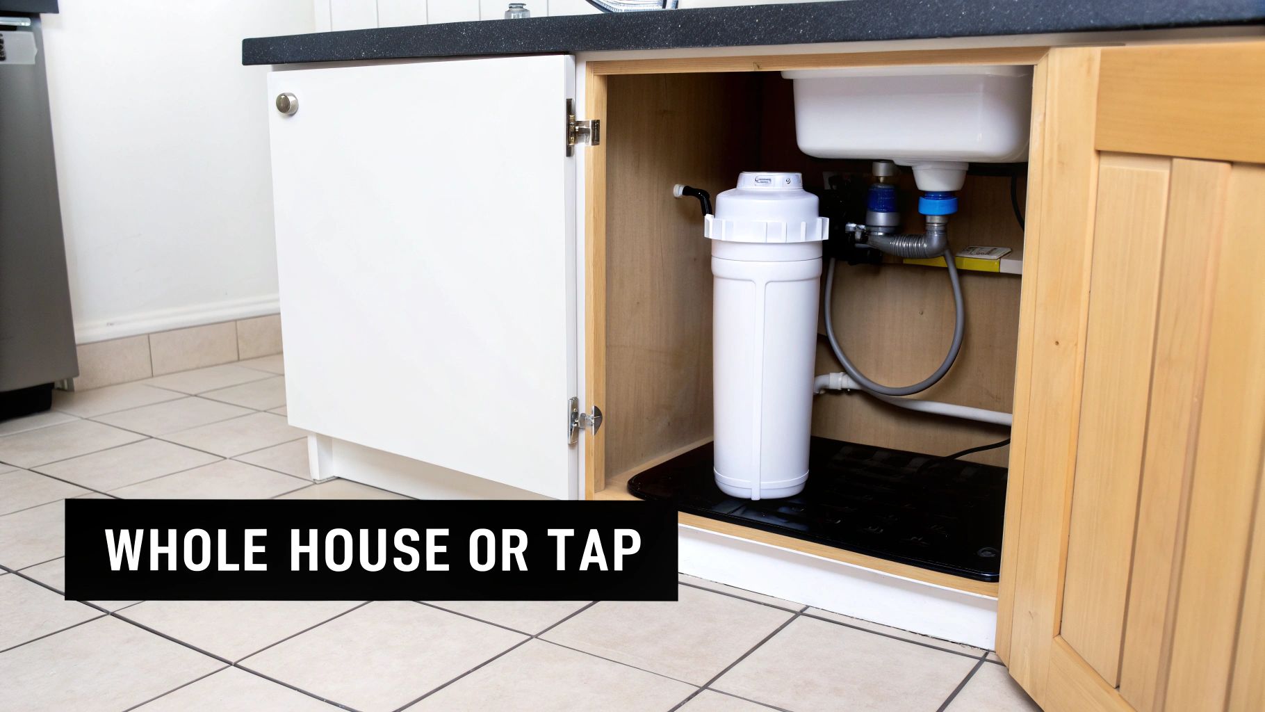 An under-sink water filtration system is installed in a kitchen cabinet below the sink.