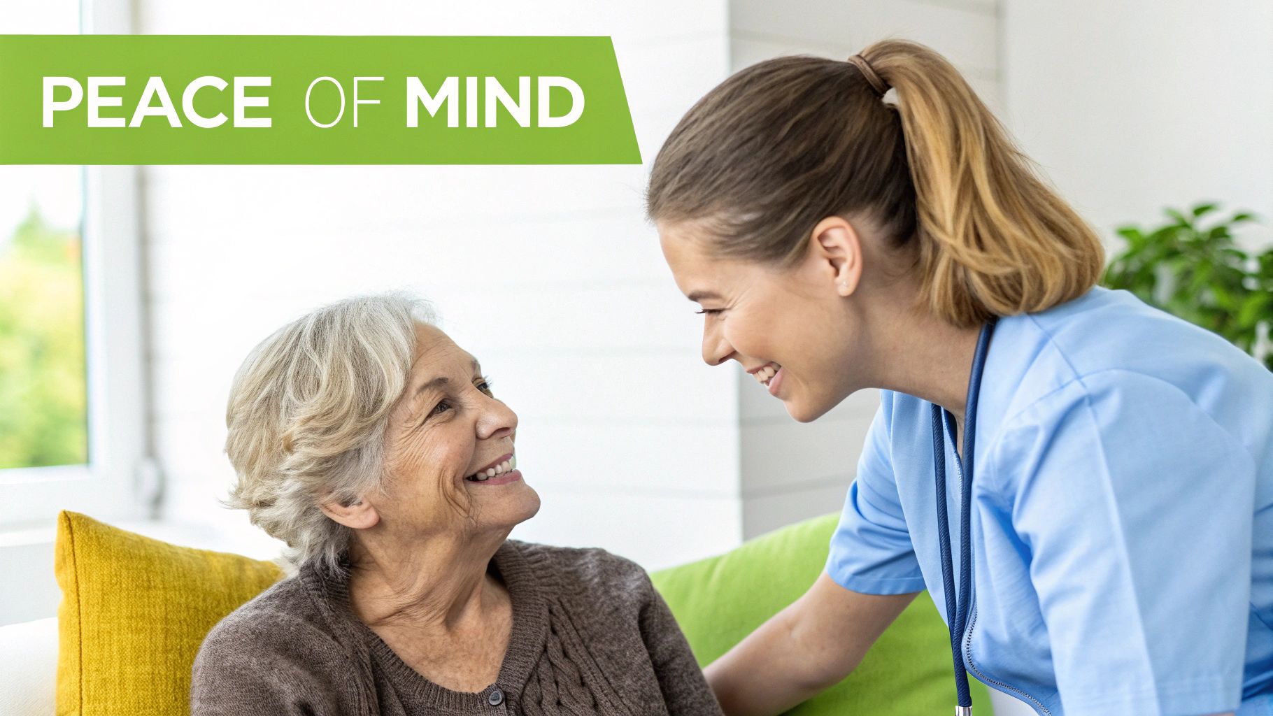 A smiling elderly woman looks at a happy caregiver in blue scrubs, symbolizing compassionate home care.