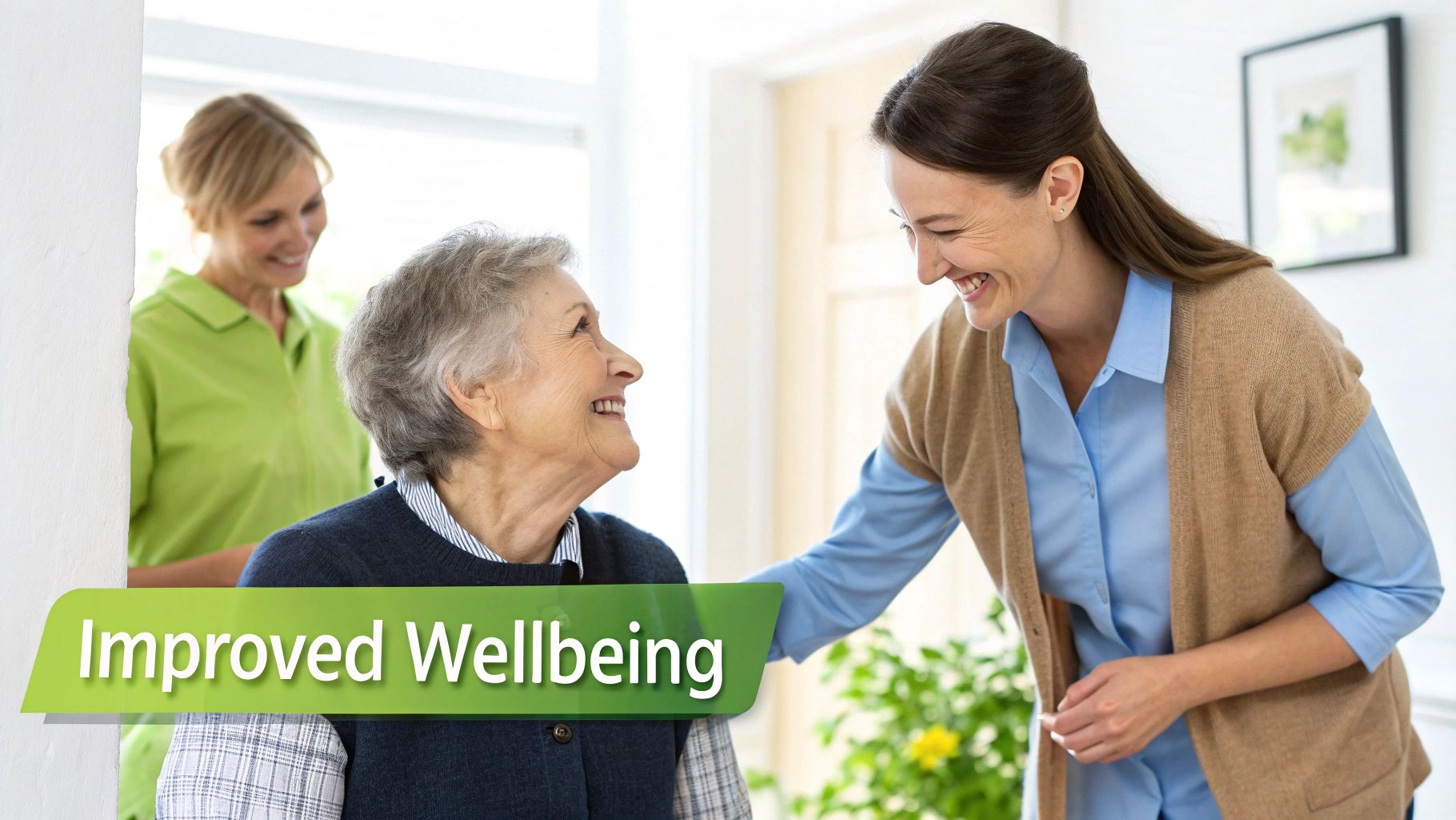 An elderly woman smiles happily at a young caregiver, with another helper in the background.