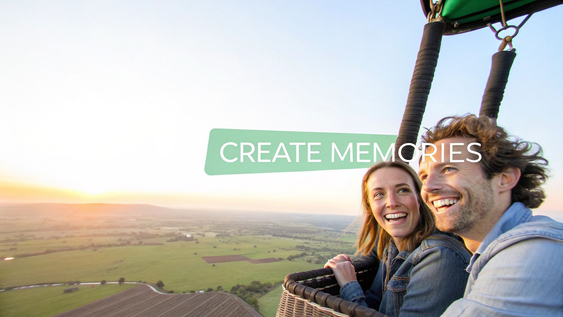 A smiling couple enjoying a scenic hot air balloon ride at sunset over a lush landscape.