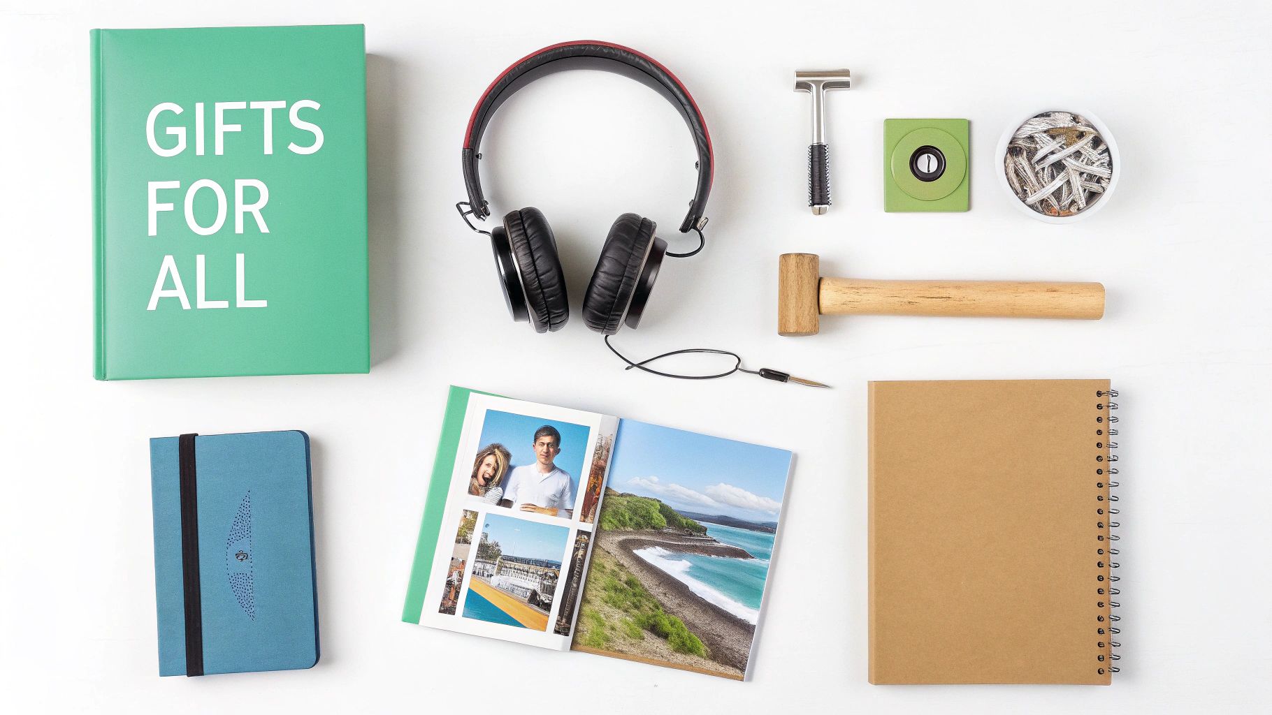 Flat lay of various gift items including headphones, notebook, photo album, and wooden hammer on white background