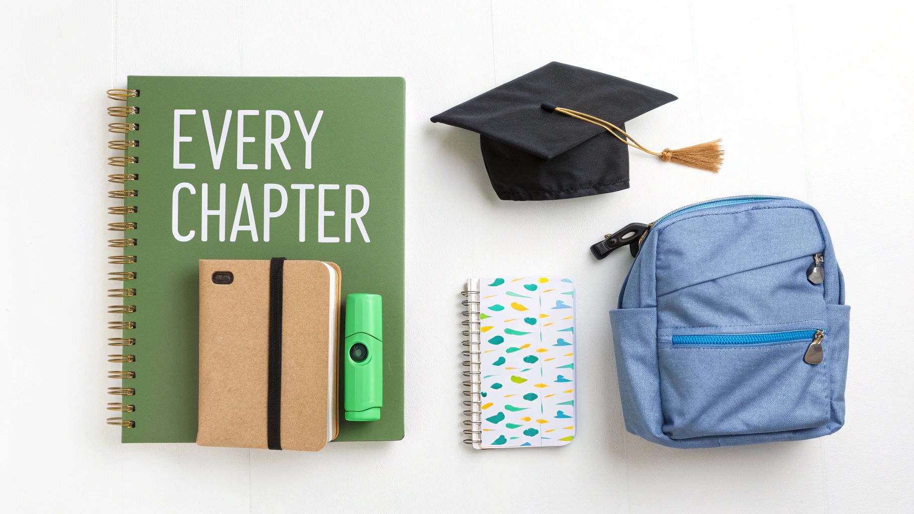 An overhead shot of education items like notebooks, a graduation cap, and a blue bag.
