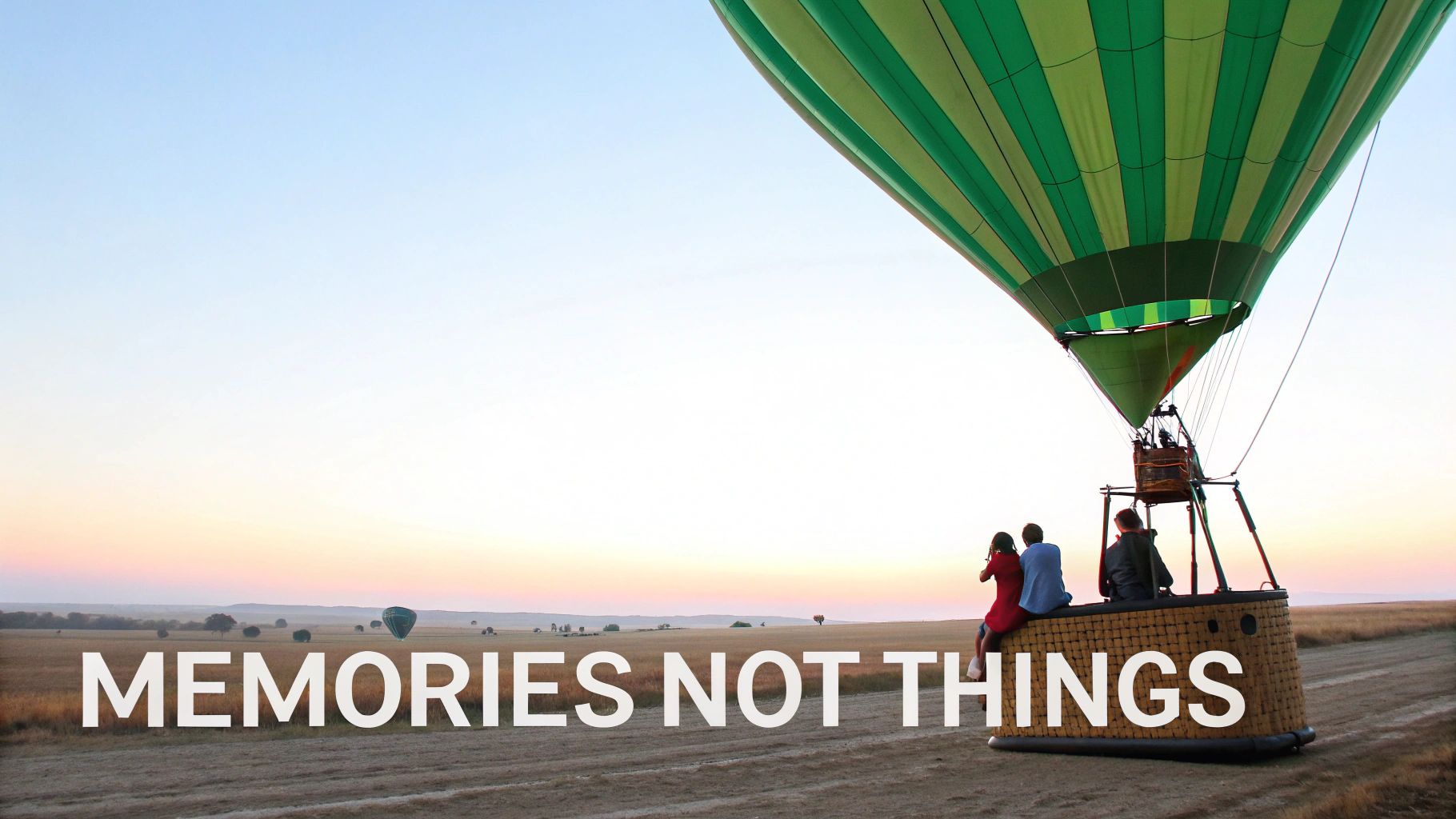 Two people's hands clinking glasses of red wine over a meal