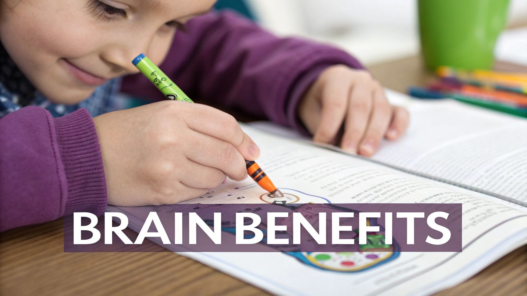A happy young child smiles while coloring in an open book with an orange crayon.