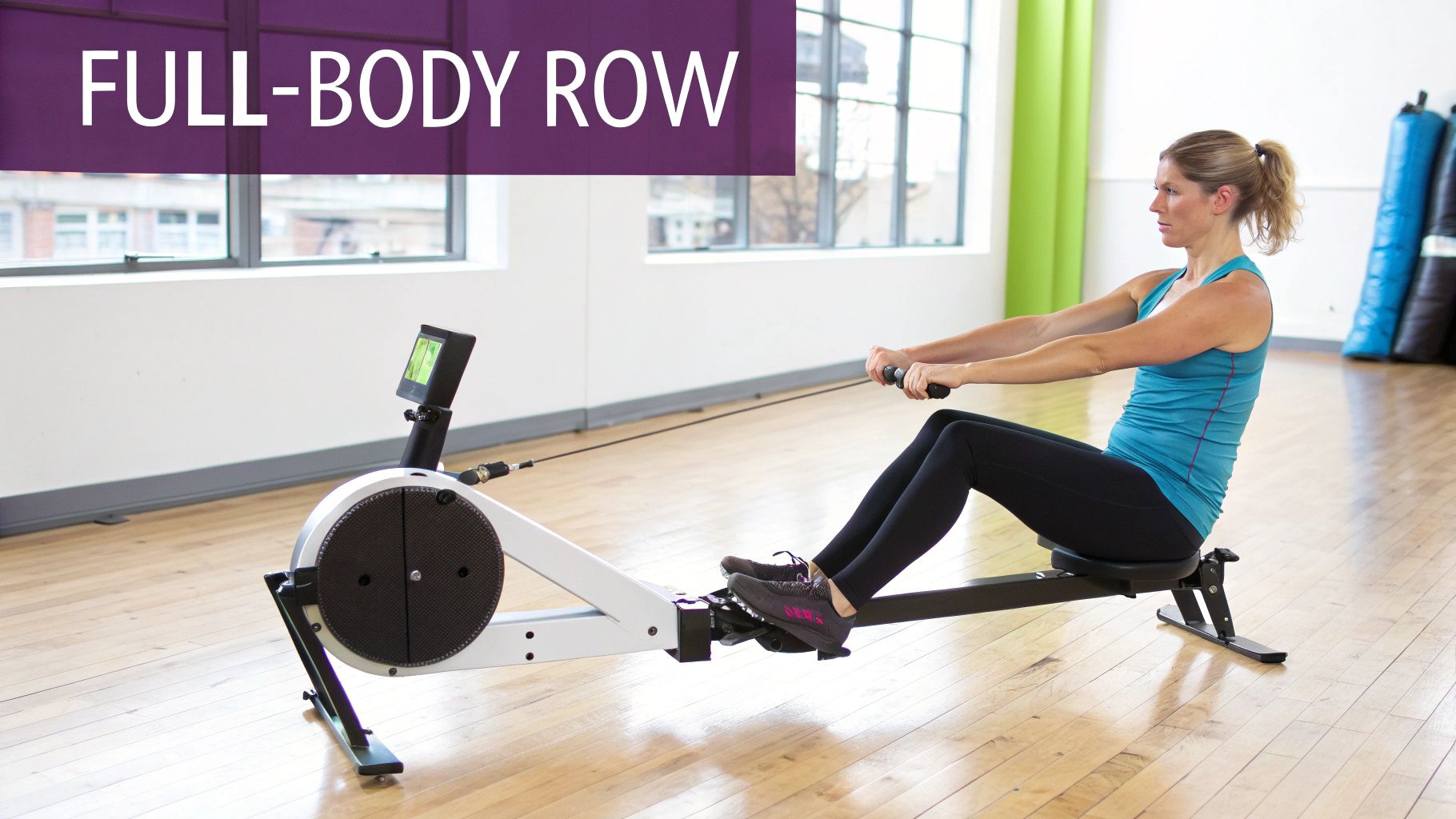 A woman demonstrates a full-body row exercise on a white and black rowing machine in a bright gym.