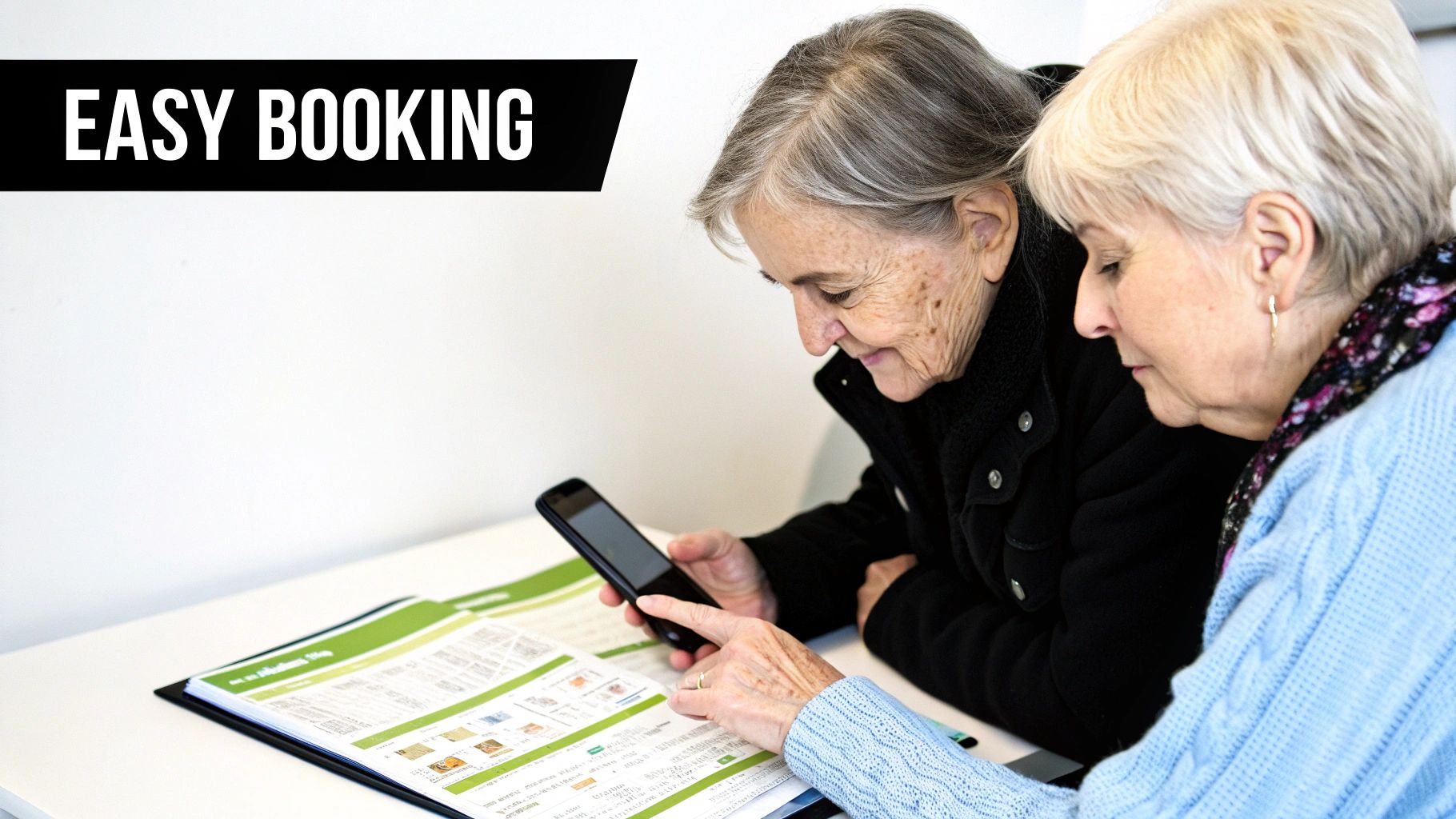 Two senior women are learning to use a smartphone for easy booking, with one pointing at the screen.