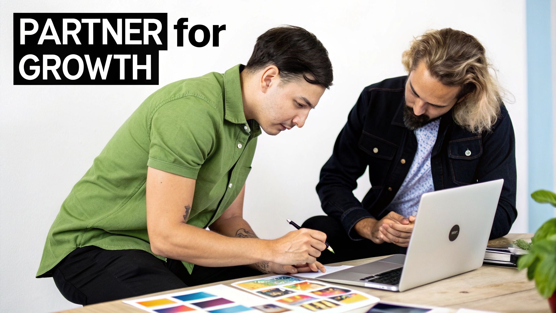 Two men collaborating at a desk, one writing notes, the other looking at a laptop, with 'Partner for Growth' text.