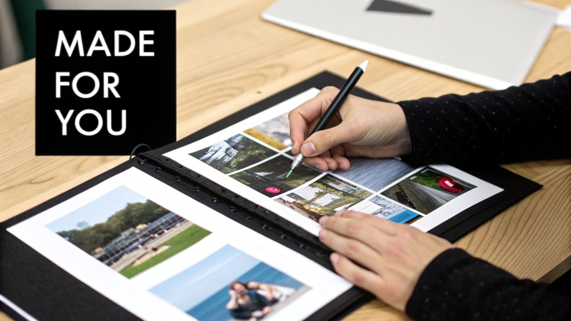 A person marking small photos in a personalized album with a pen, beside a 'MADE FOR YOU' sign.