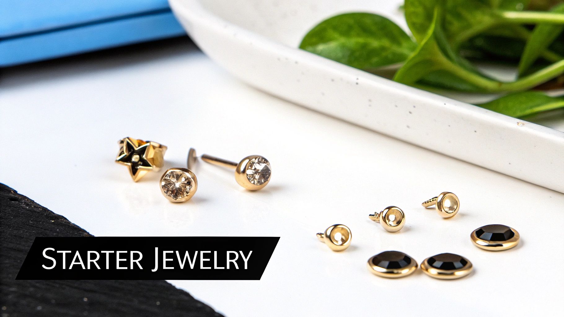 Assortment of gold starter ear piercing jewelry, including star, clear gem studs, and black gem settings.