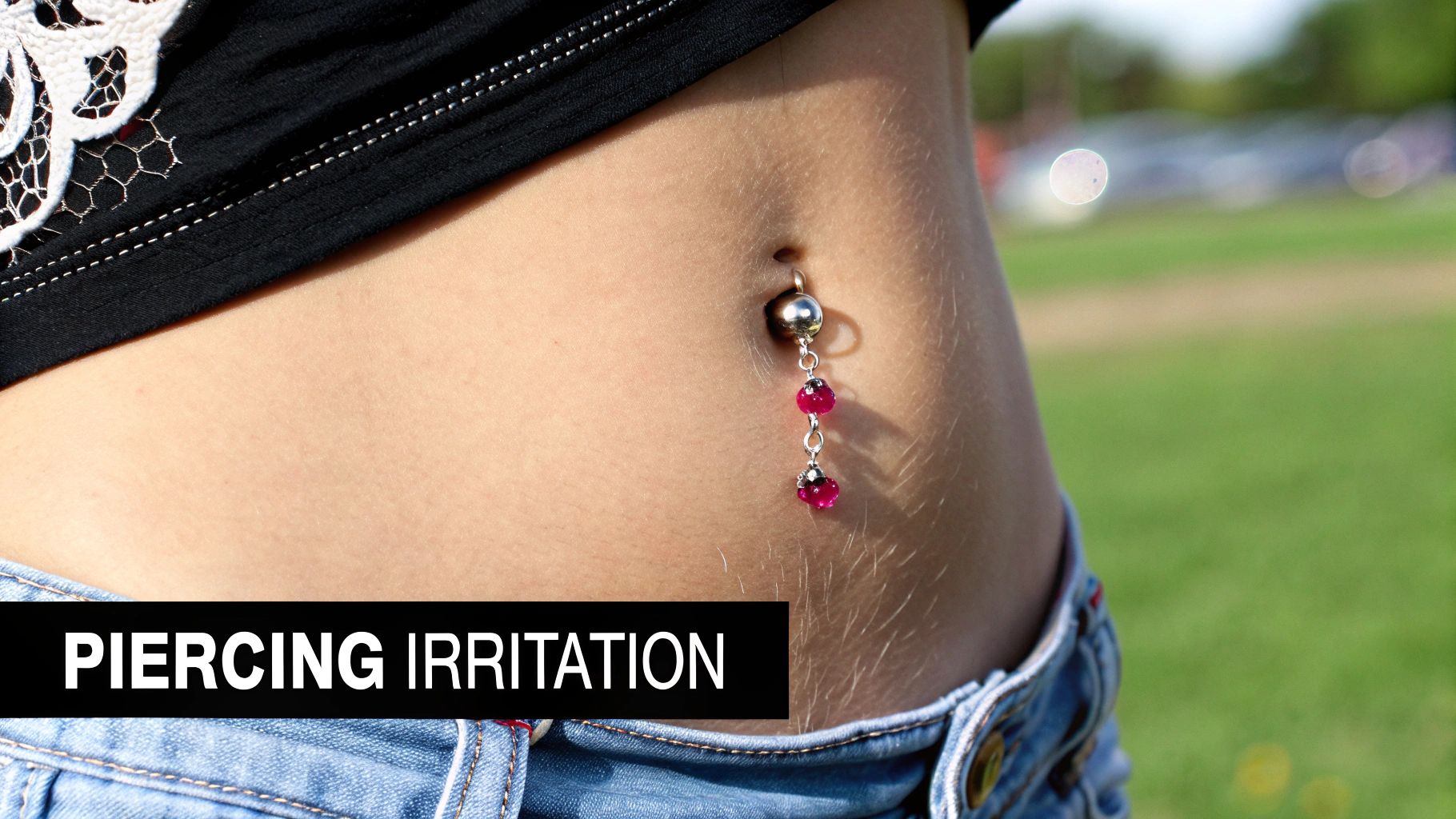 A close-up of a navel piercing with a simple, elegant belly button ring.