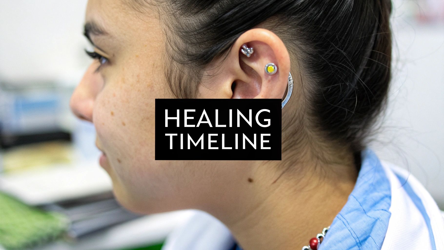 Woman showcasing healing conch piercing with multiple colorful ear piercings and jewelry visible