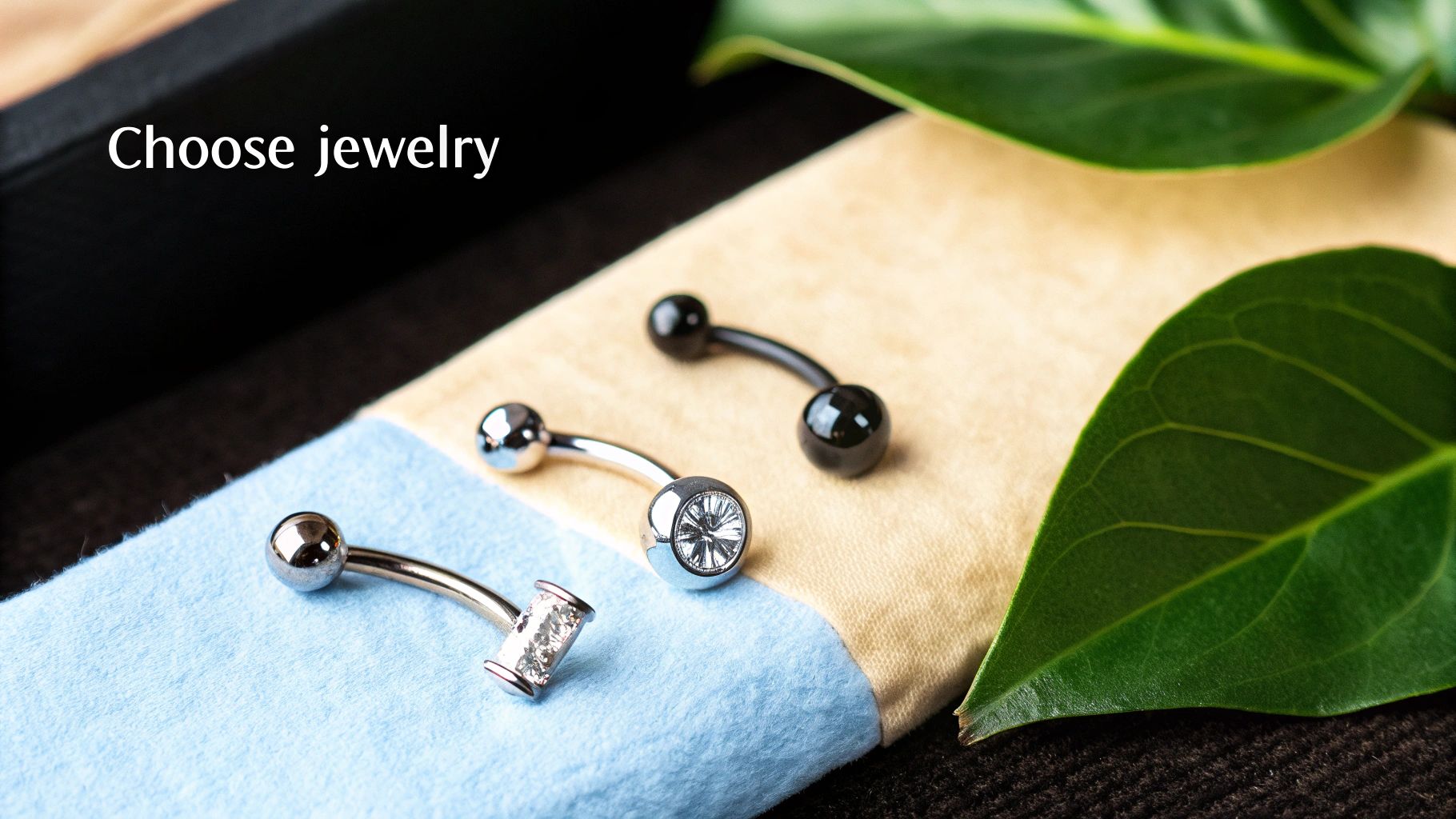 Shiny belly button piercing jewelry, including silver and black curved barbells with gems.