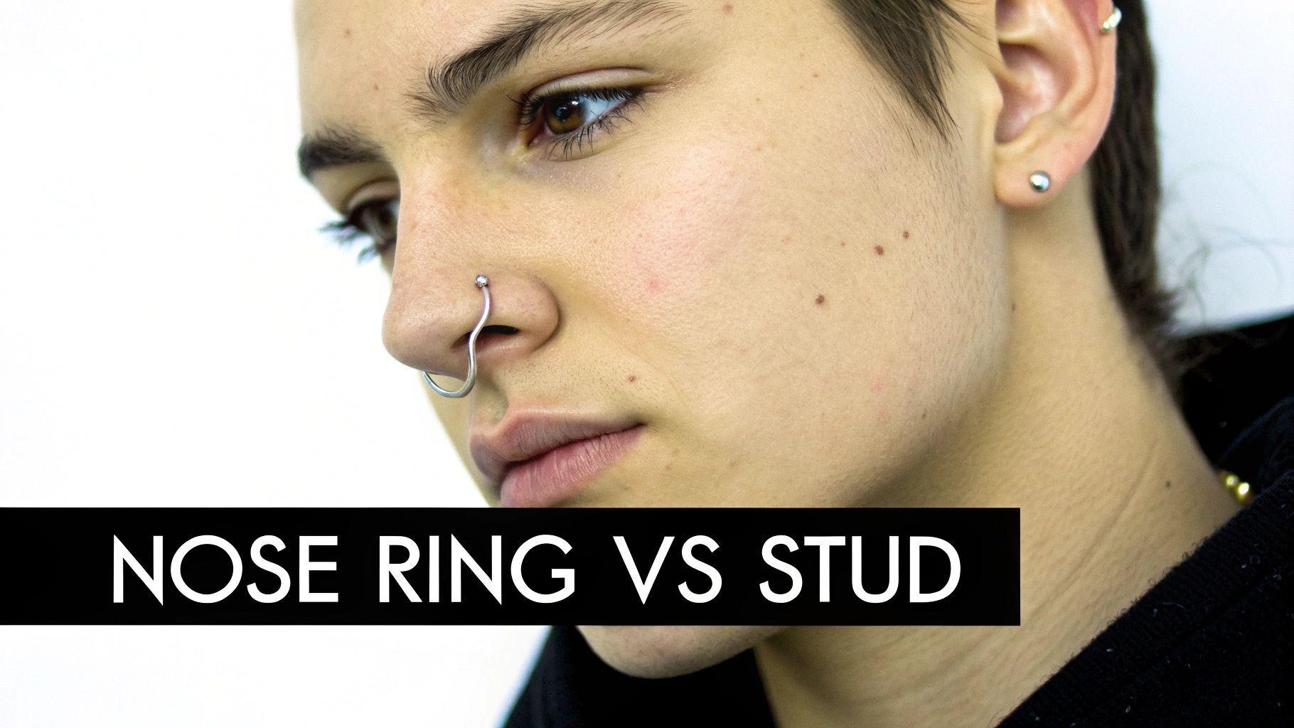 Close-up of a person's face featuring a silver nose ring and an ear stud, with text 'NOSE RING VS STUD'.