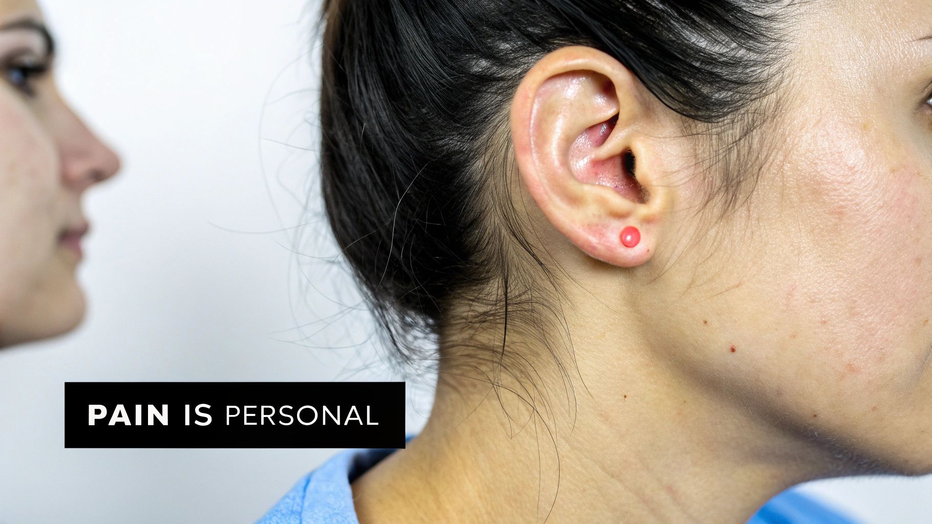 Close-up of a person's ear with a small red stud, highlighting pain relief or therapy.