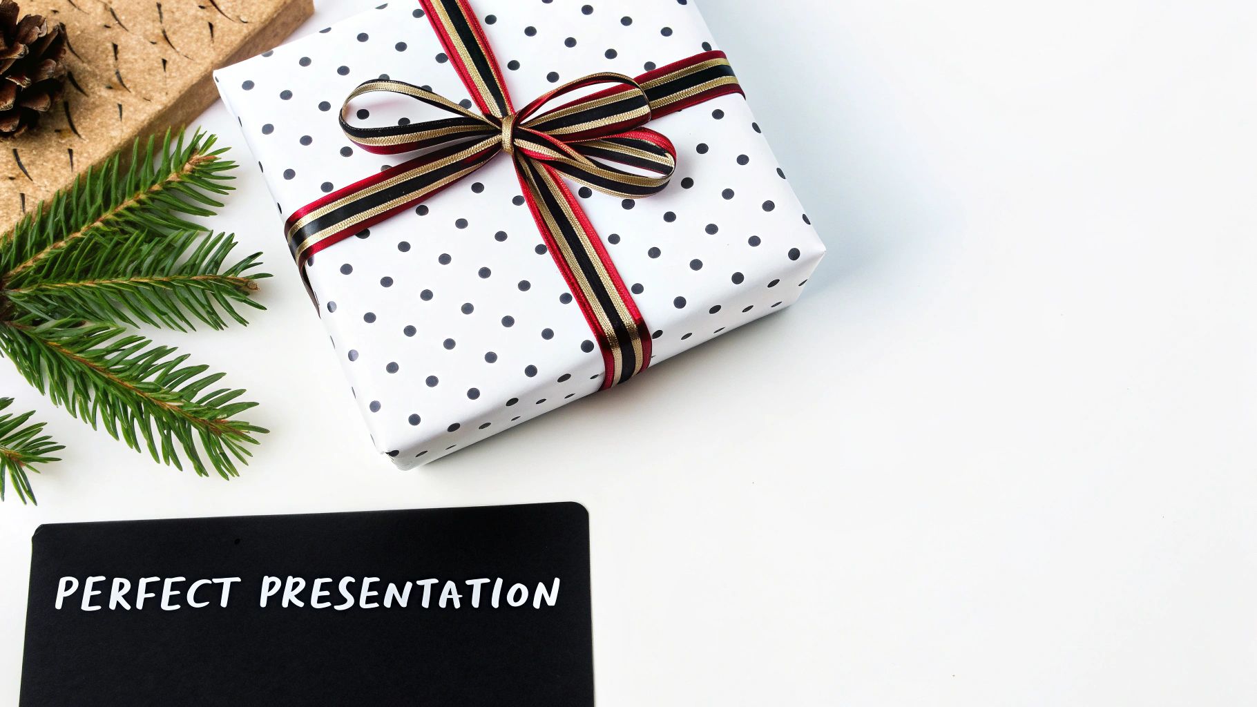 A festive flat lay with a polka dot gift box, pine branch, pine cone, and 'PERFECT PRESENTATION' text.
