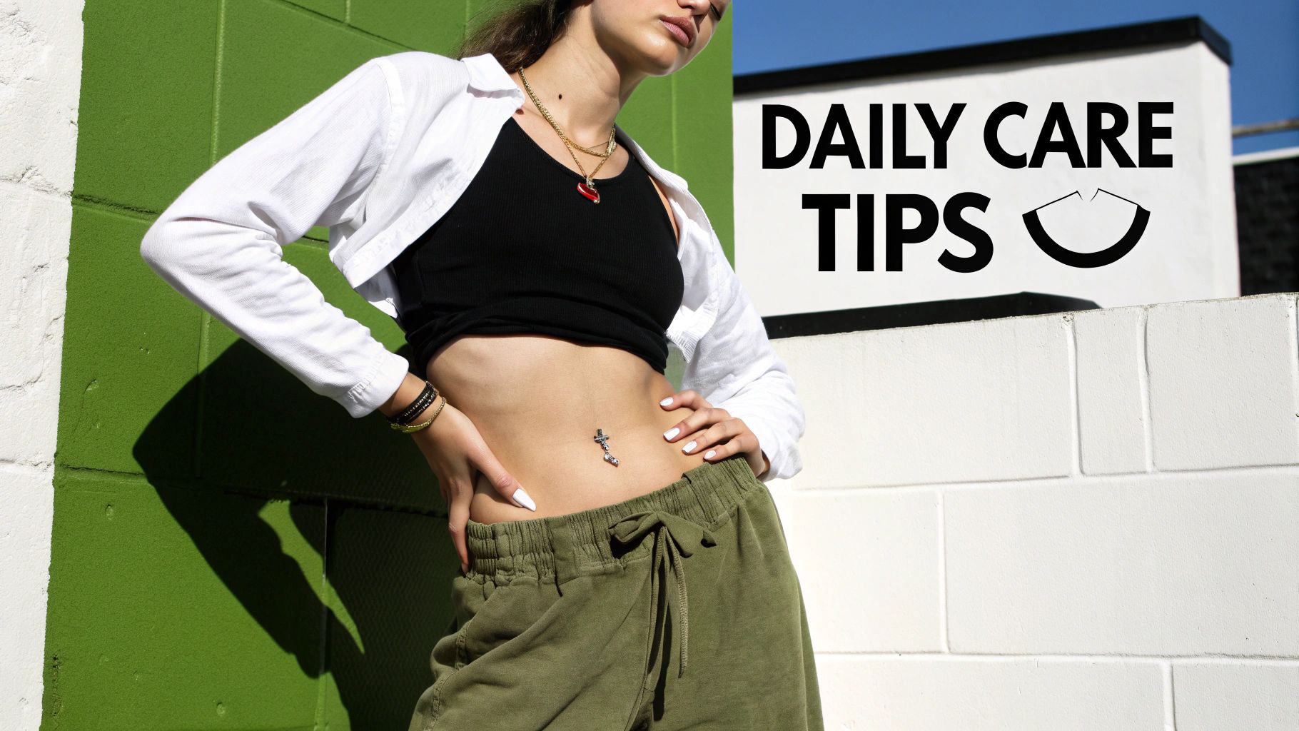 A person in comfortable, loose-fitting clothing, showing off their navel piercing.