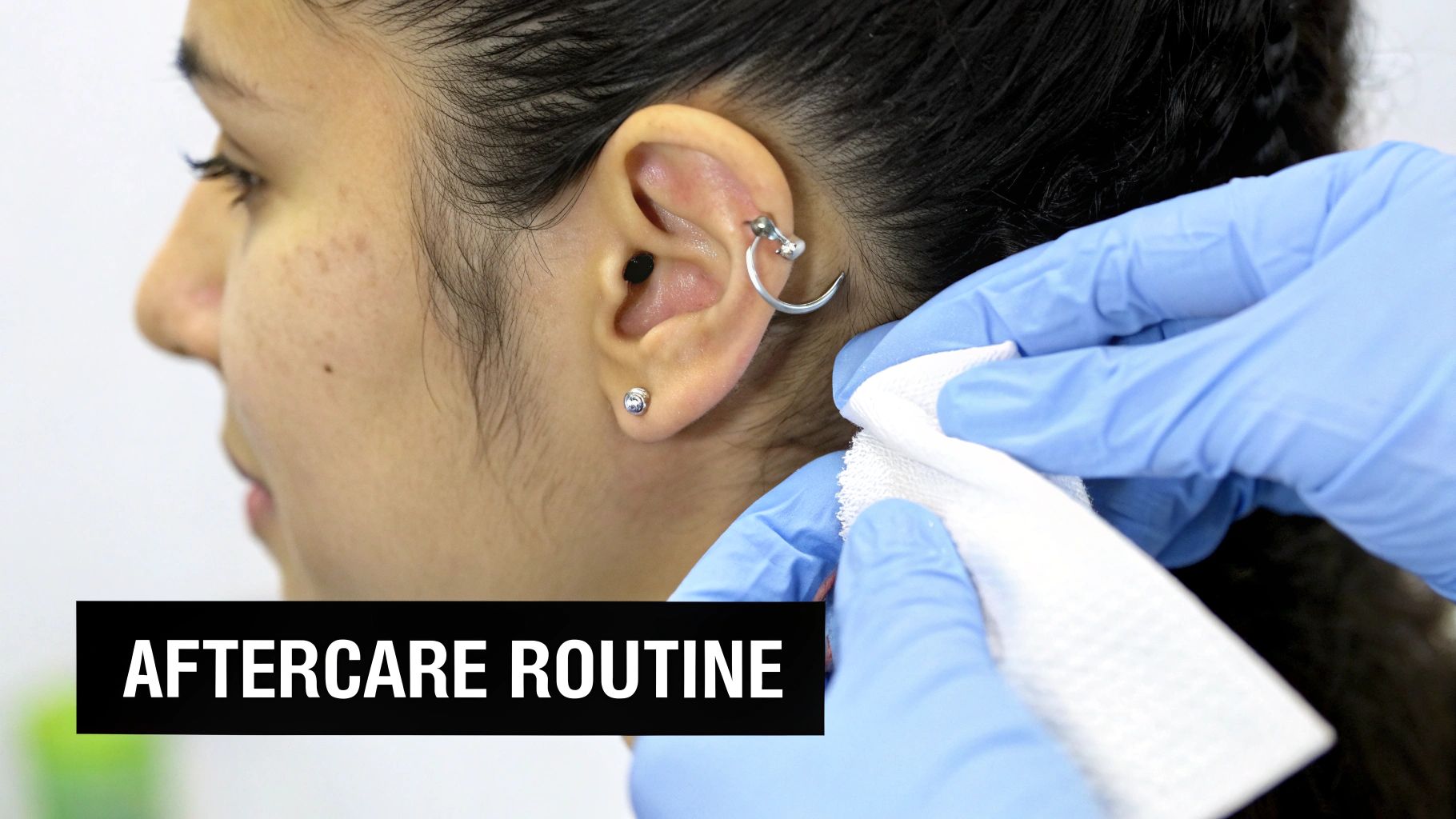 A person's ear with a freshly pierced helix, showing off a simple stud.