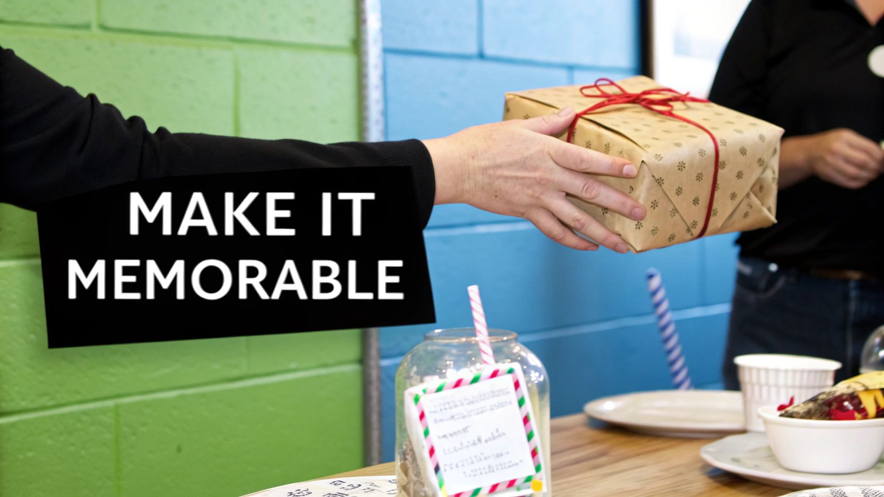 A person's hand offers a brown, red-tied gift with a black sign saying 'Make it Memorable'.