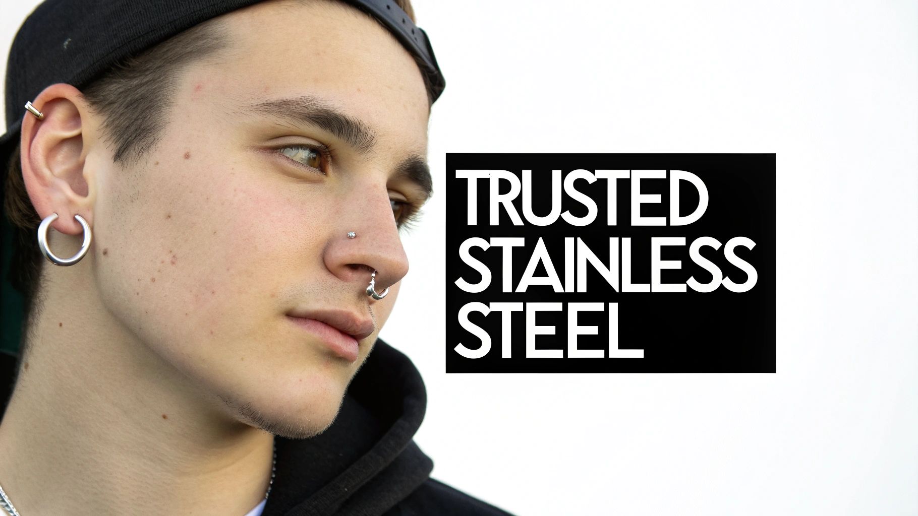 Young person with multiple stainless steel body piercings, including ear hoops, a nose stud, and a septum ring.