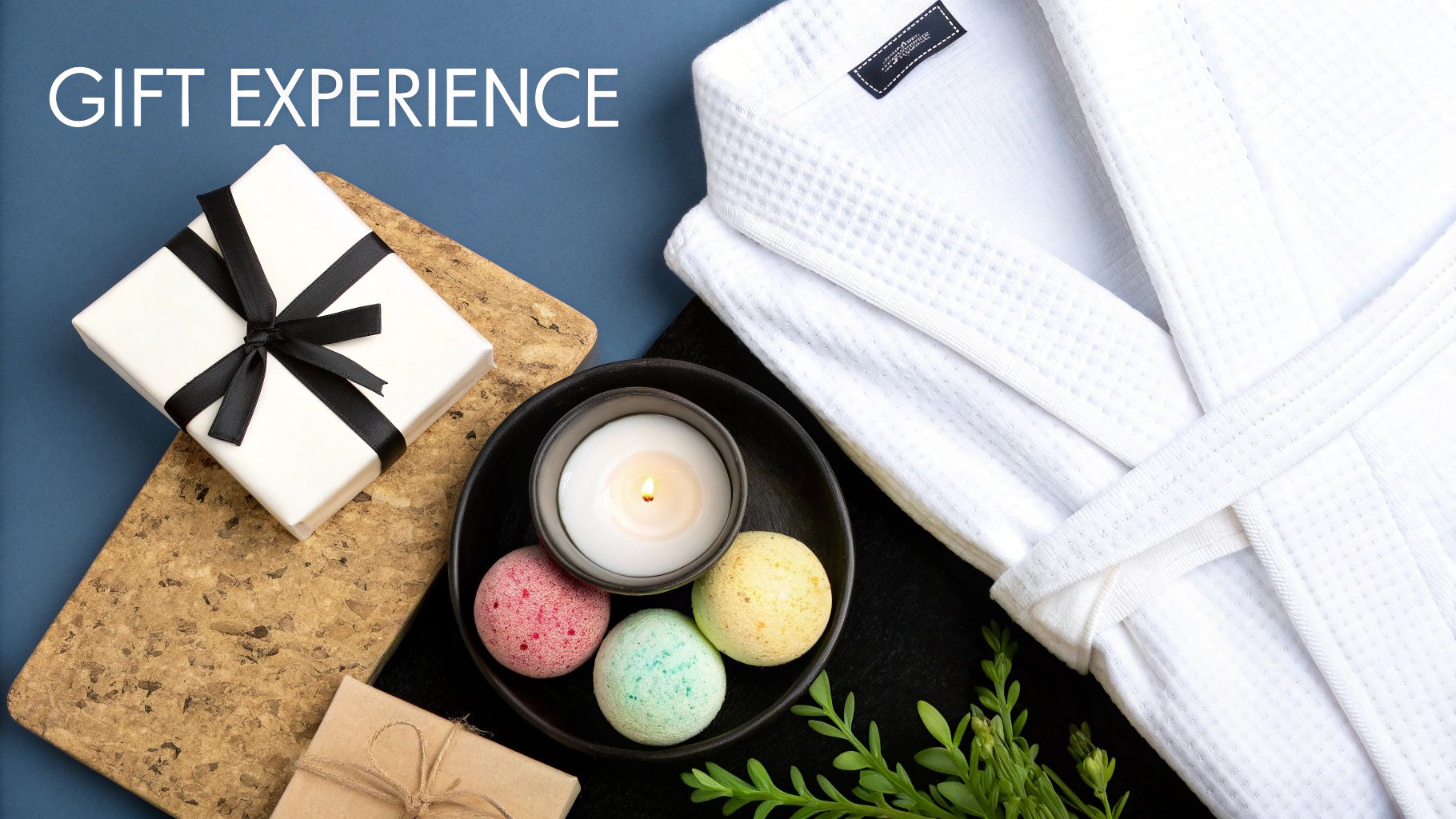 A luxurious gift experience set with a white bathrobe, colorful bath bombs, a lit candle, and gift boxes.