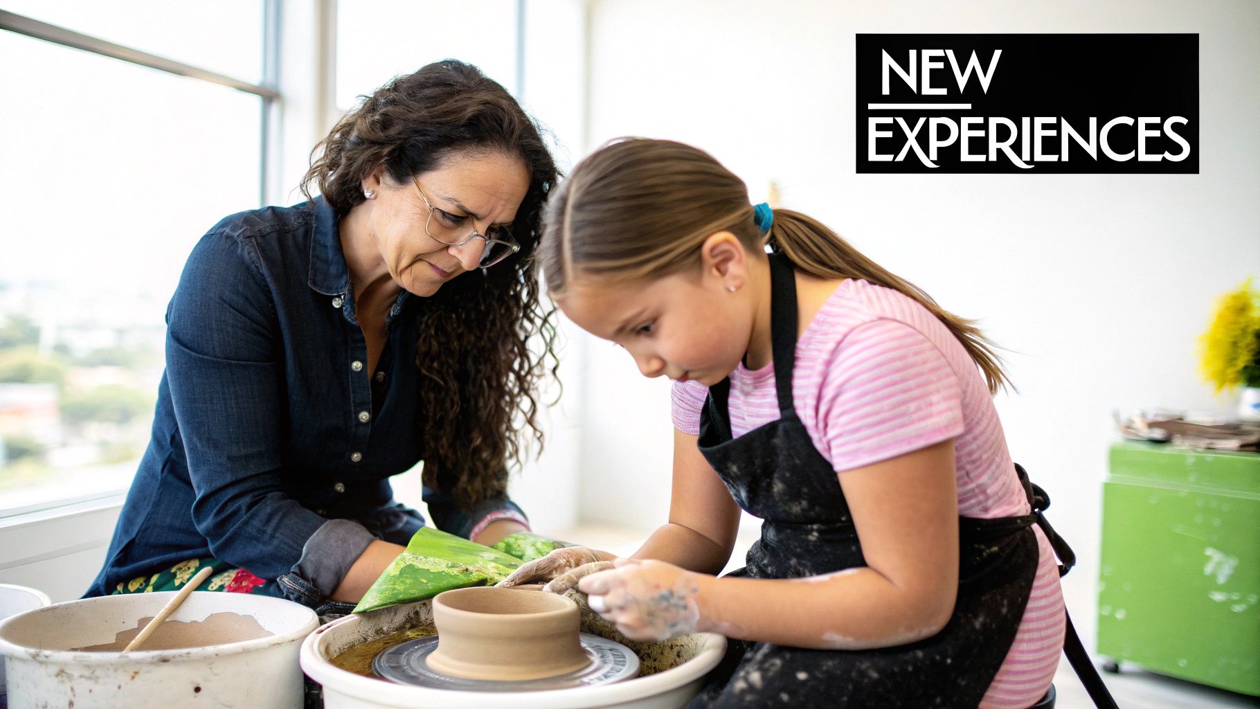 A mother and daughter laughing together while pottery-making in a bright workshop.