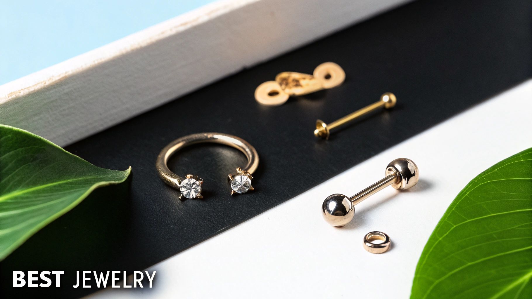 A collection of gold-colored ear cartilage piercing jewelry with sparkling gems, displayed on a black and white surface.