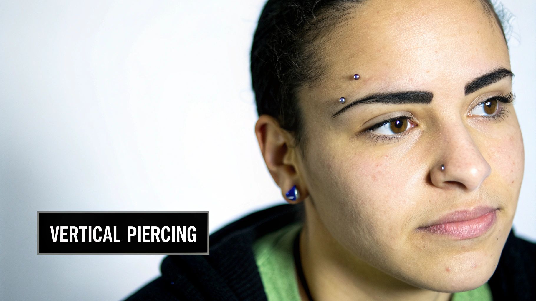 A person with a horizontal eyebrow piercing showing the placement and jewelry.