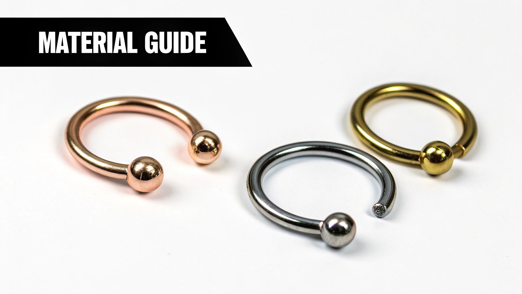 Three metal body piercing rings: a rose gold horseshoe, a silver circular, and a gold captive bead ring.