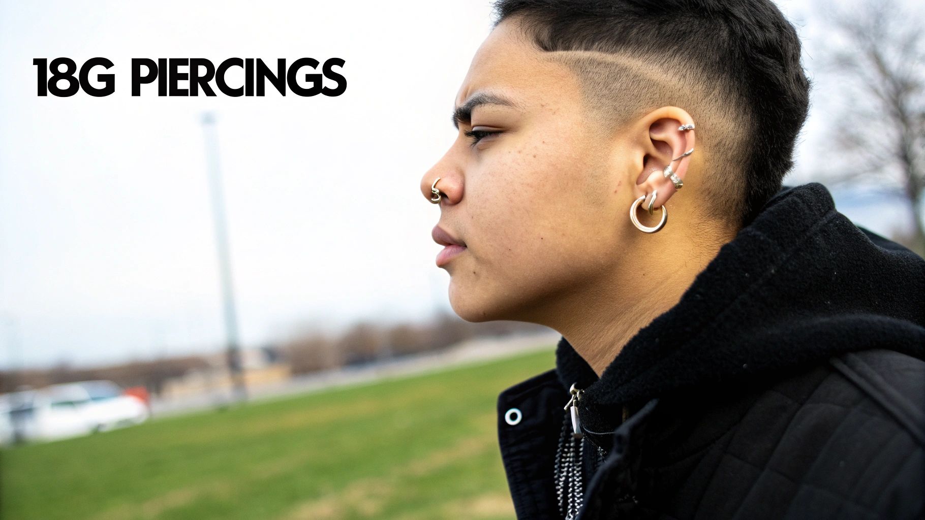 A person with a nose ring and multiple ear piercings, displaying an edgy style.