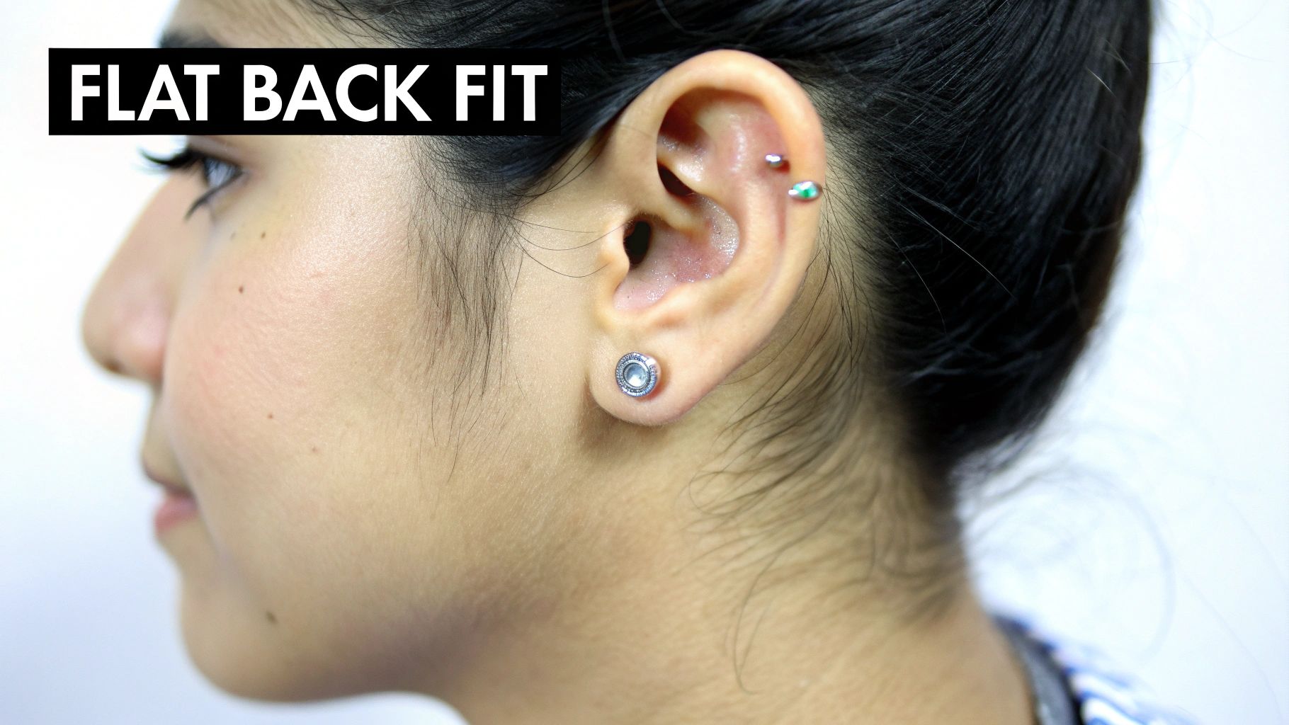 A close-up side profile of a woman's ear featuring multiple flat back fit cartilage and earlobe piercings.