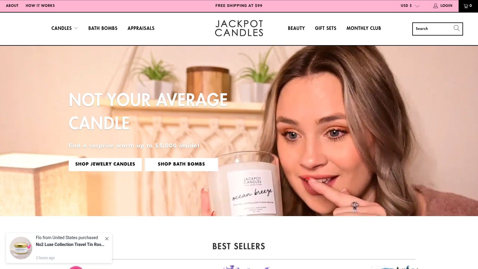 A beautiful Jackpot Candle with a birthday cake scent, next to a revealed piece of jewelry.
