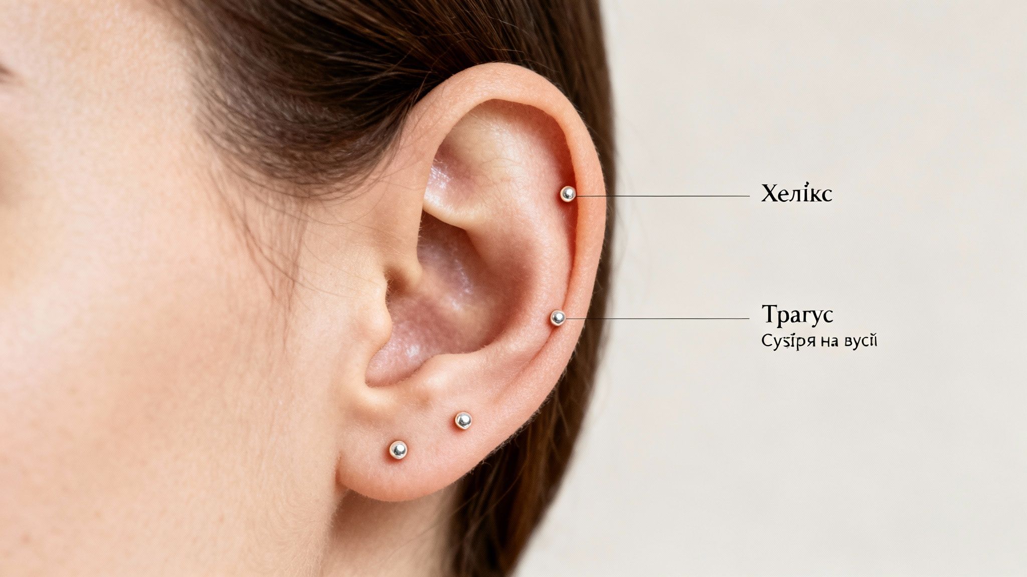 Крупний план жіночого вуха з пірсингом хелікс, трагус та пірсингом мочки вуха.