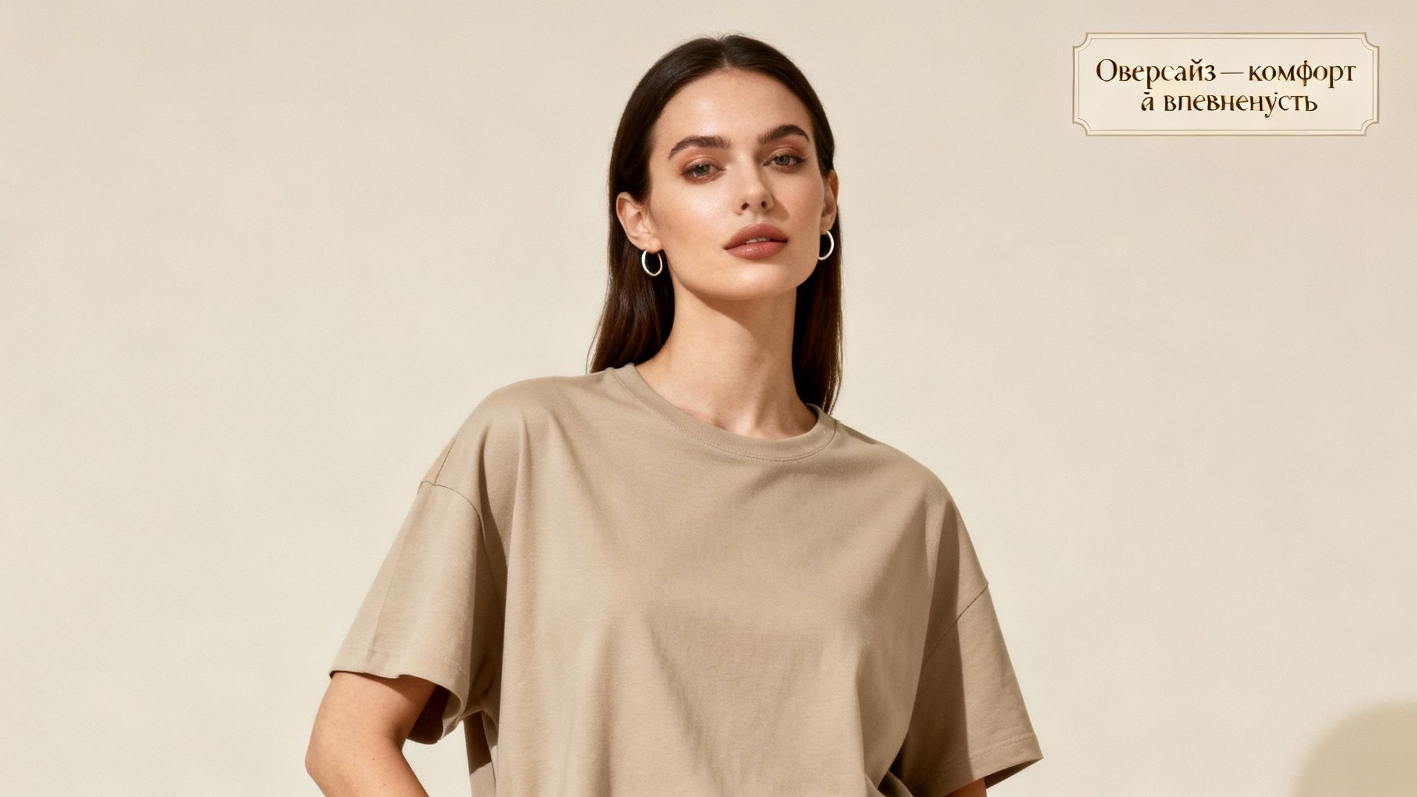 Молода жінка в стильному бежевому оверсайз футболці стоїть на світлому фоні, текст про комфорт і впевненість.