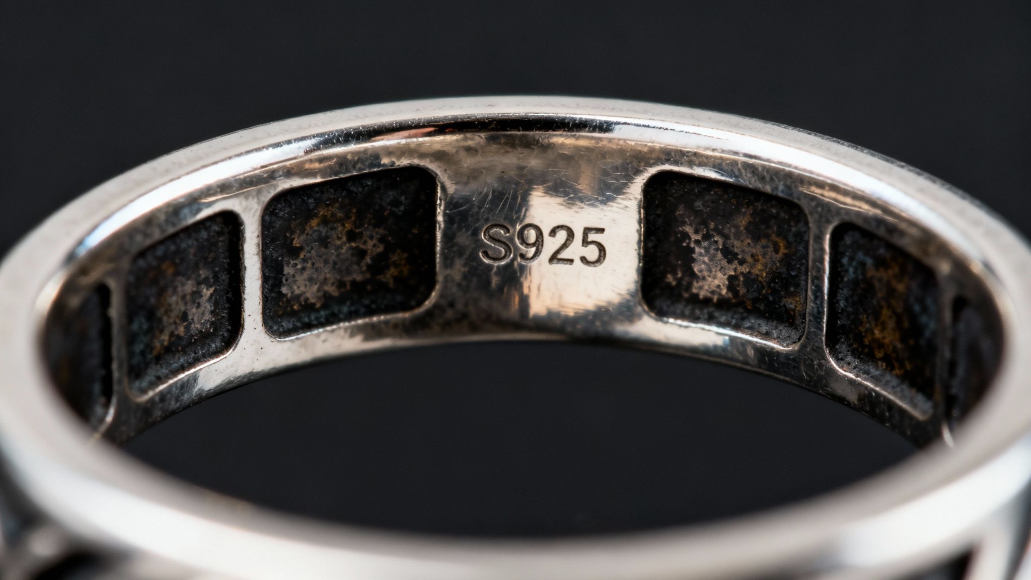 Close-up of the inside of a sterling silver ring, prominently displaying the S925 hallmark.