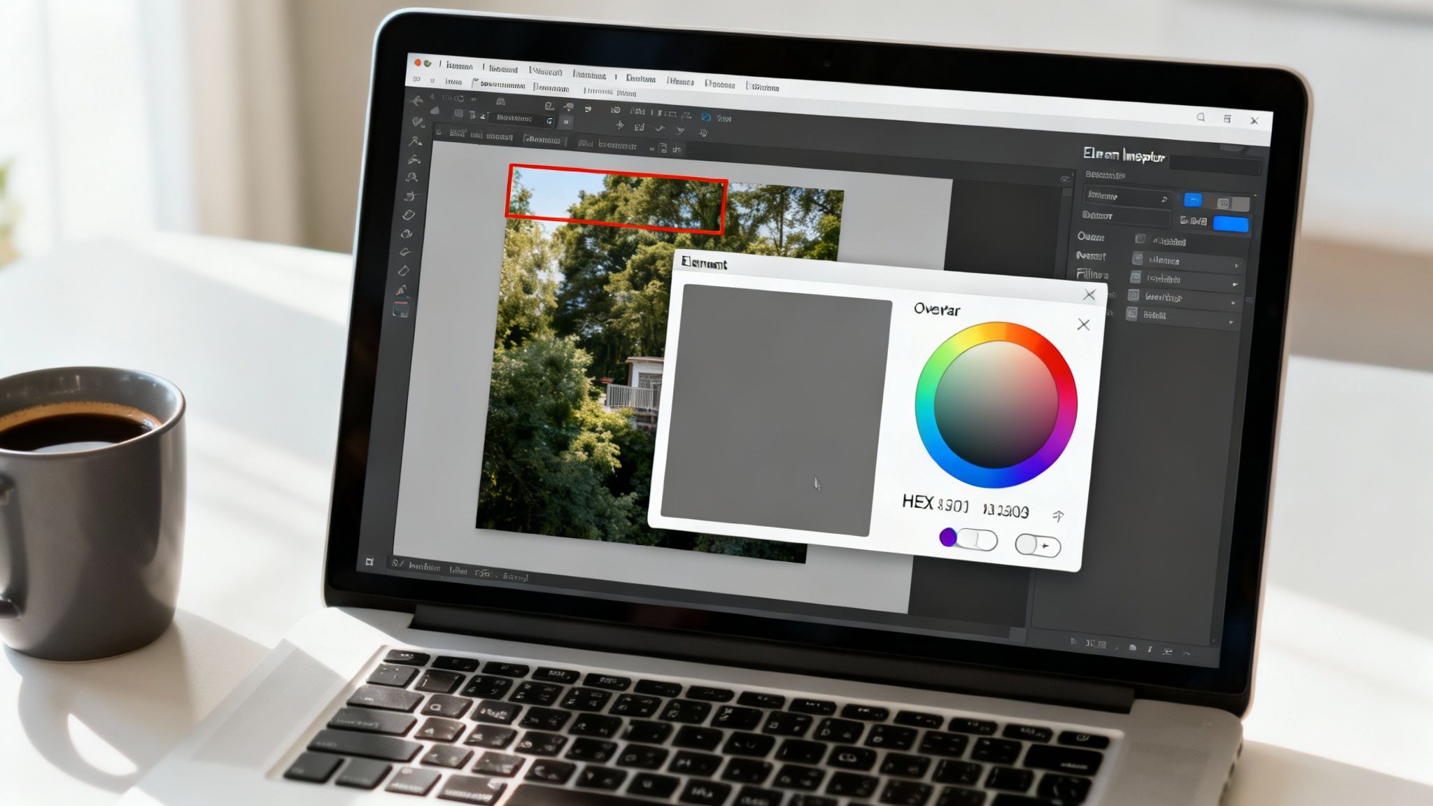 Laptop on a desk displaying photo editing software with a color picker window and a coffee mug.