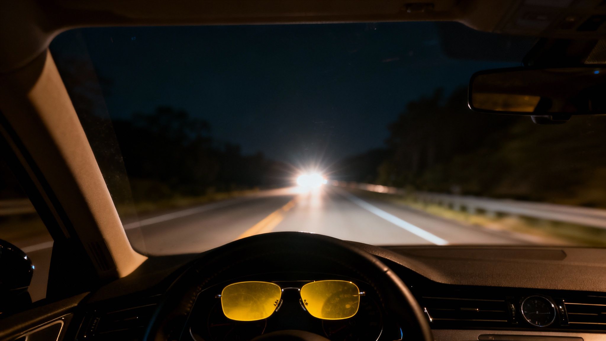A winding road at night with car headlights creating long streaks of light