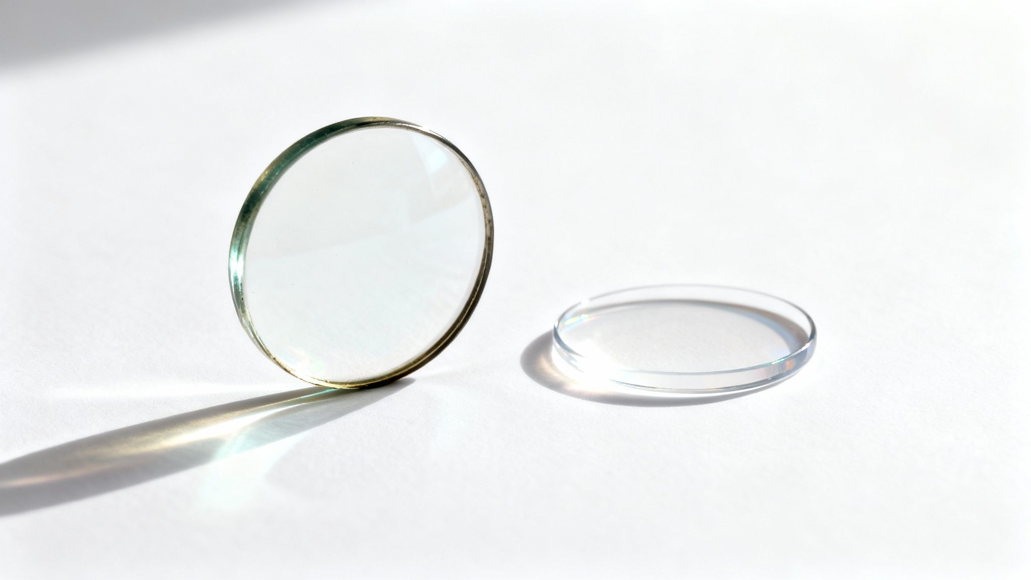 A pair of old-fashioned, thick-lensed glasses resting on a historical document, showing their bulkiness.