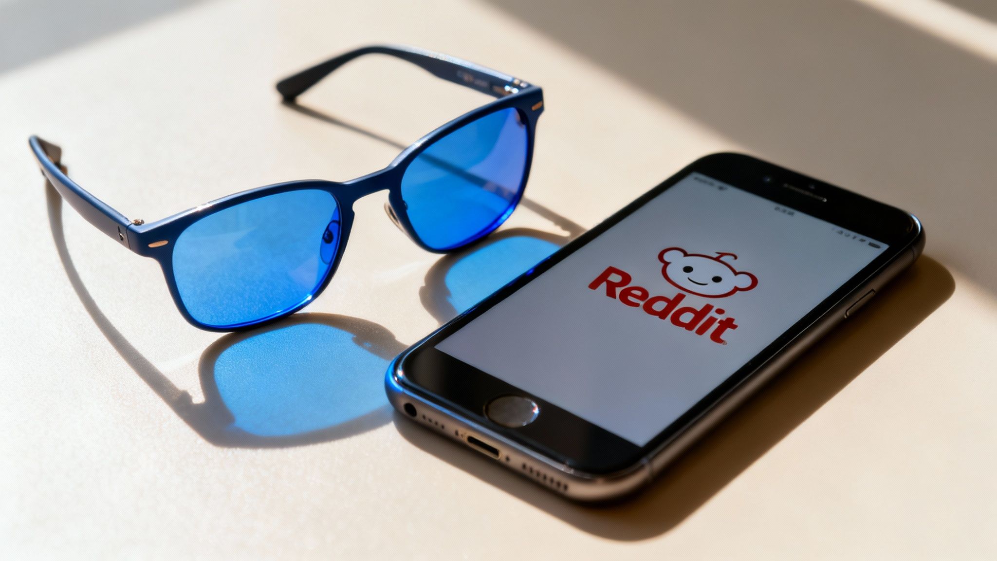 A person wearing stylish blue light glasses while working on a laptop, looking focused and comfortable.