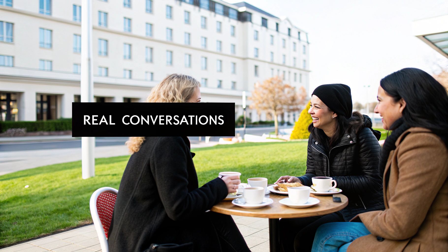 Diverse women enjoy coffee and conversation outdoors, fostering real connections.
