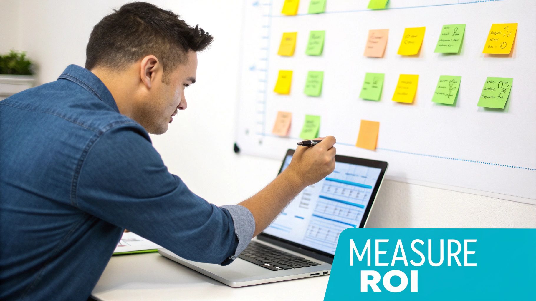 A man analyzing data on a laptop, pointing at the screen, with a whiteboard of sticky notes, focusing on measuring ROI.
