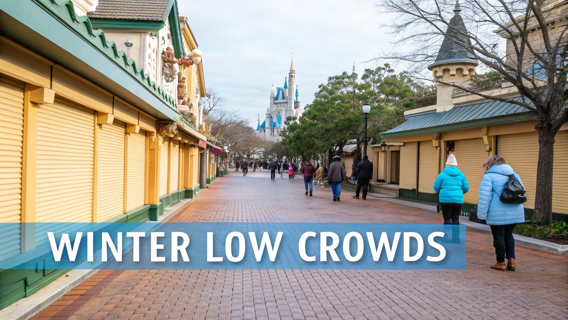 A theme park street in winter showing Cinderella's Castle, closed shops, and few visitors.