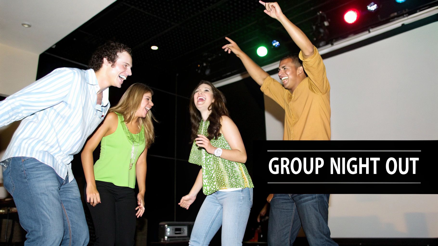 Four happy young adults laughing and dancing together during a lively group night out.
