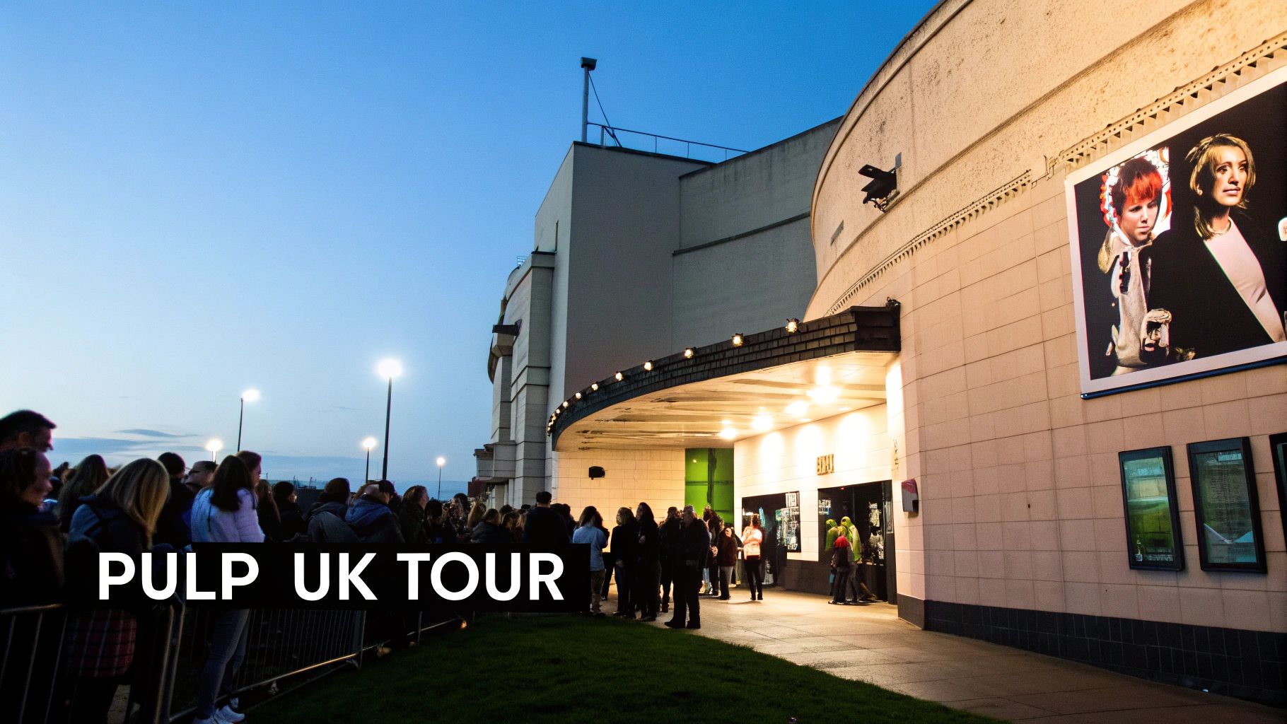 Crowd queues outside a large building with a concert poster, awaiting the Pulp UK Tour event at dusk.