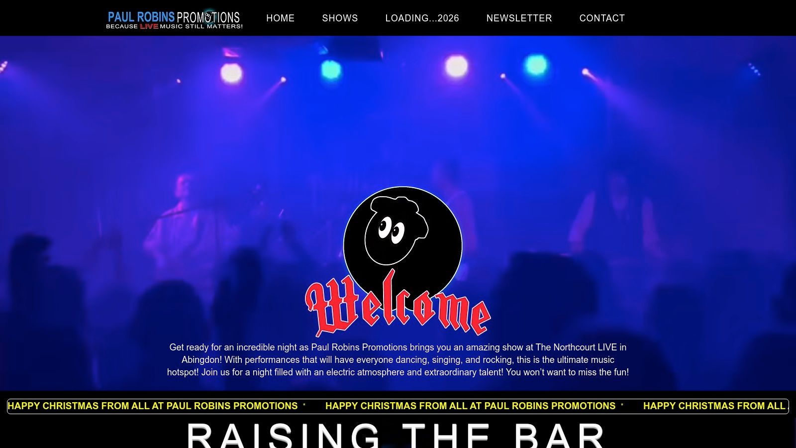 Live concert showing a band performing on stage with dynamic lighting