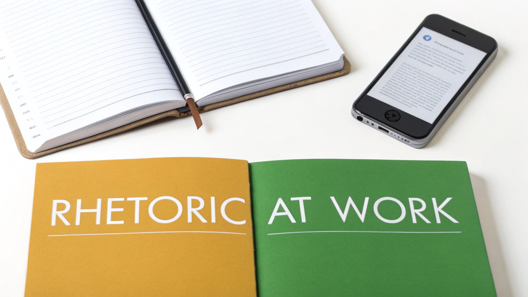 Overhead shot of an open notebook, a smartphone, and books on 'Rhetoric at Work'.