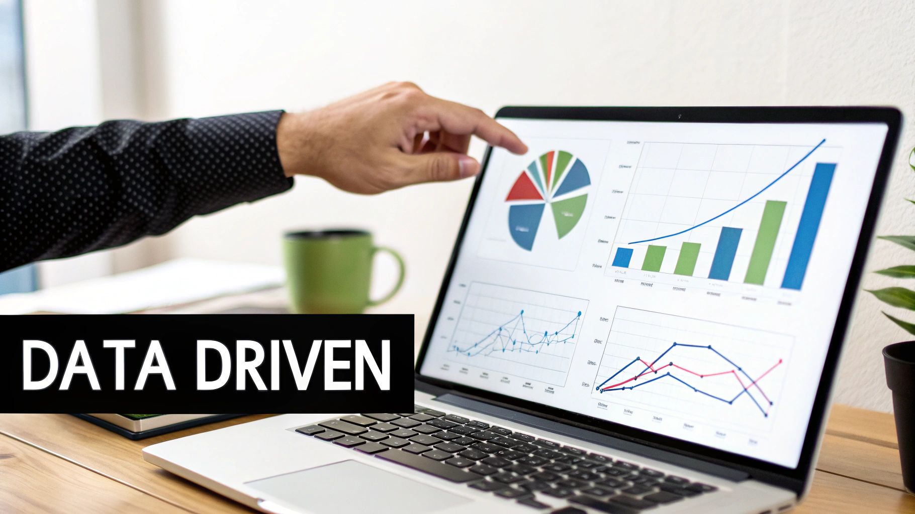 A hand points at a laptop screen displaying data-driven business charts and graphs with 'DATA DRIVEN' text.