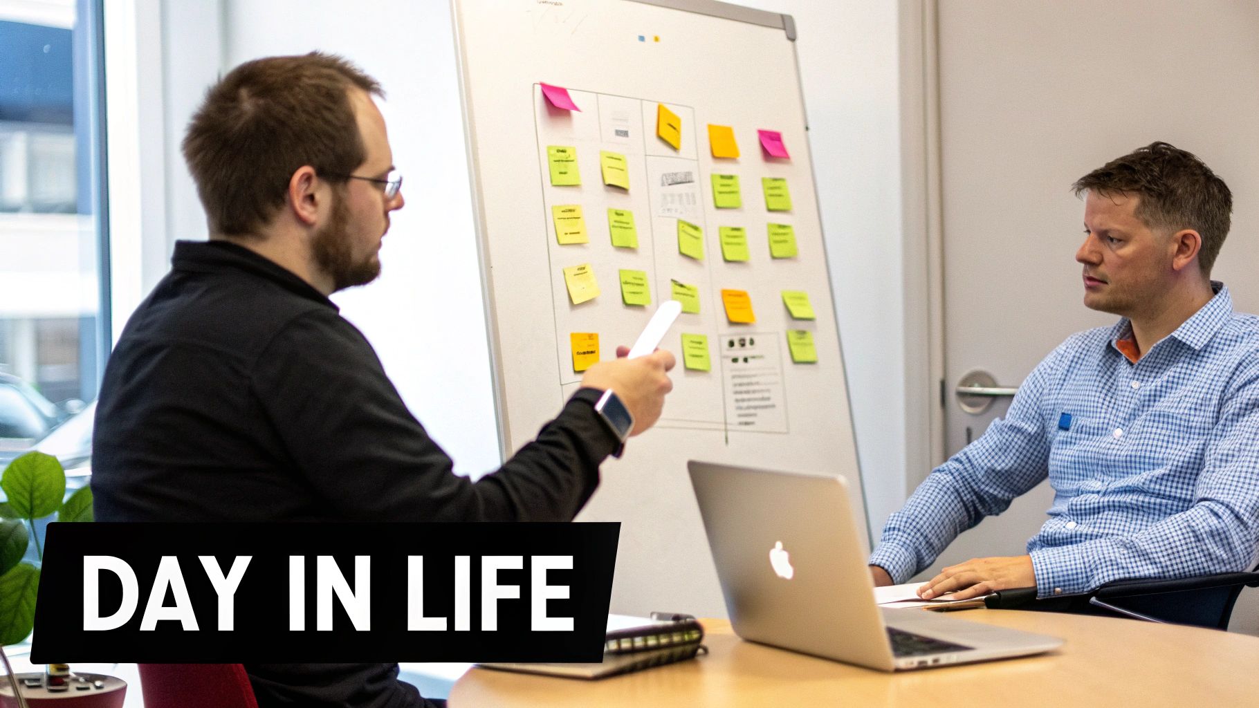 Product owner and manager discuss project ideas using a whiteboard with colorful sticky notes.